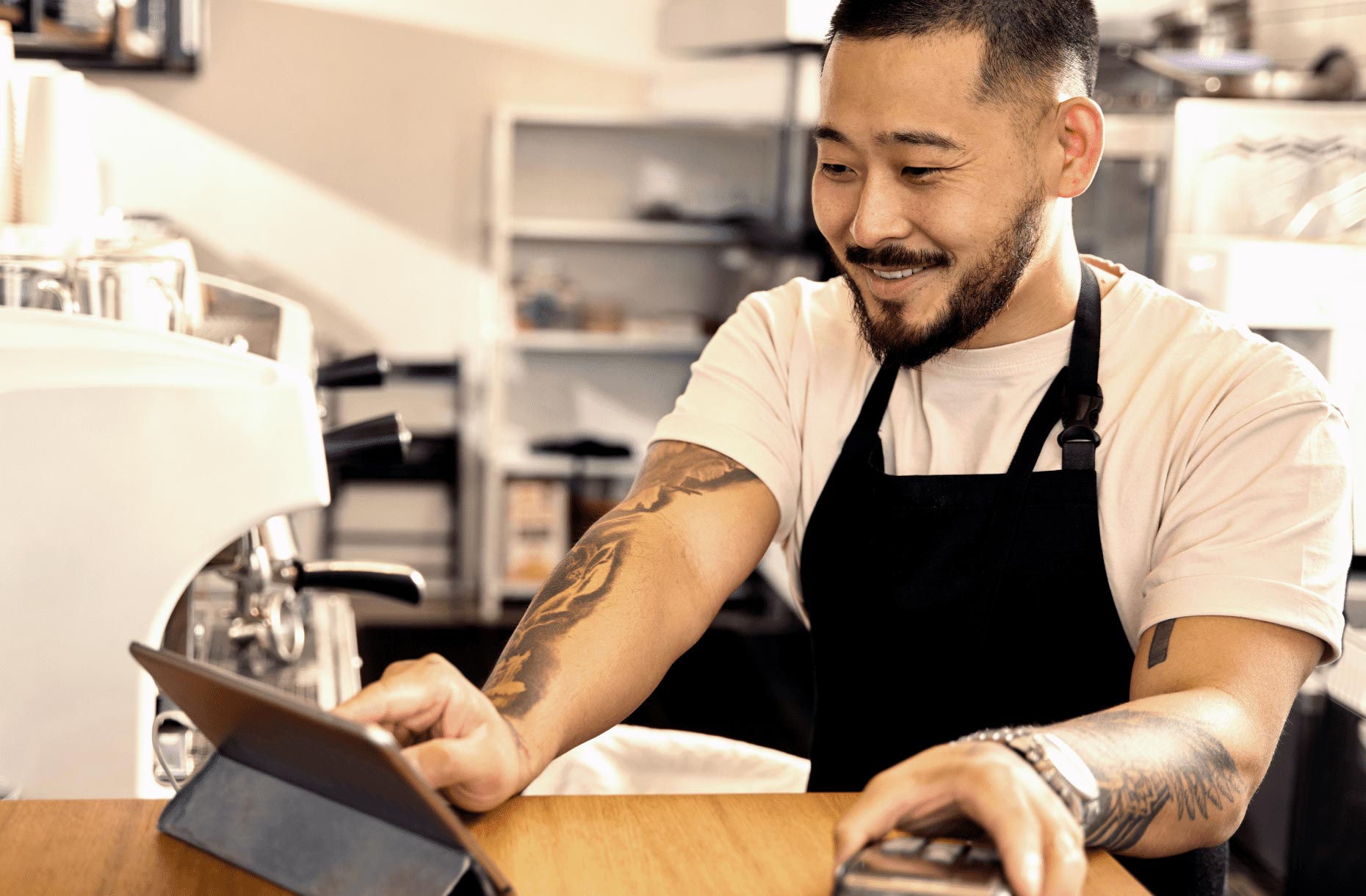 Man at café processing a payment with tablet and EFTPOS terminal