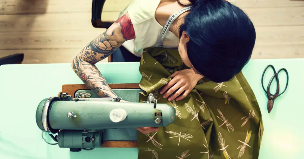 Small business owner working on a sewing machine supported by Prospa funding
