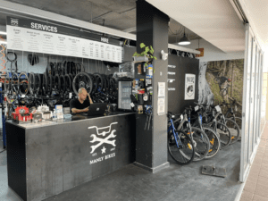 Bike shop owner standing in his store, representing small business growth and support