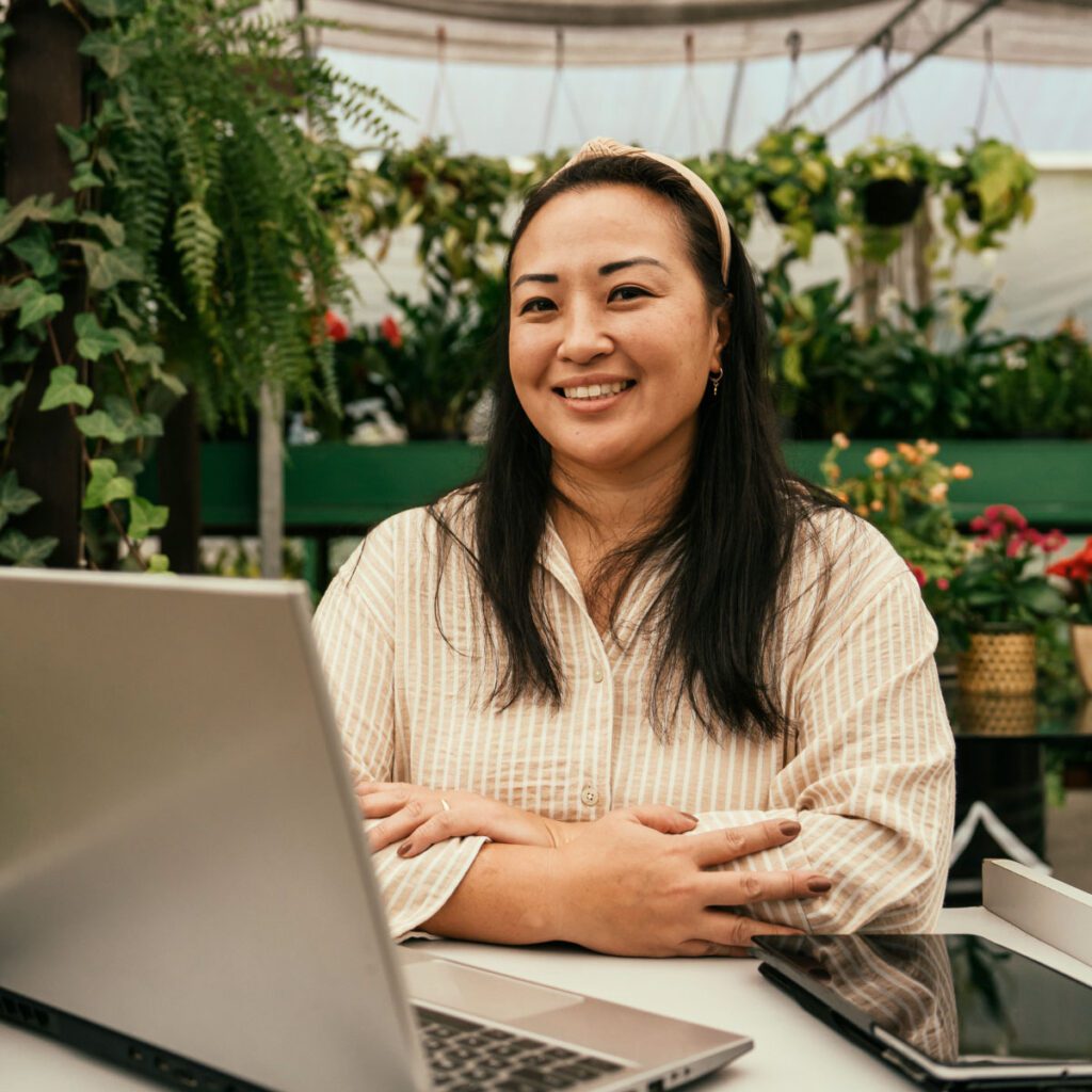 Florist owner in her shop sitting near her work laptop and iPad