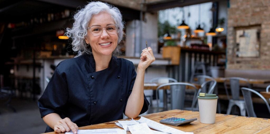 Chef doing taxes while smiling at camera