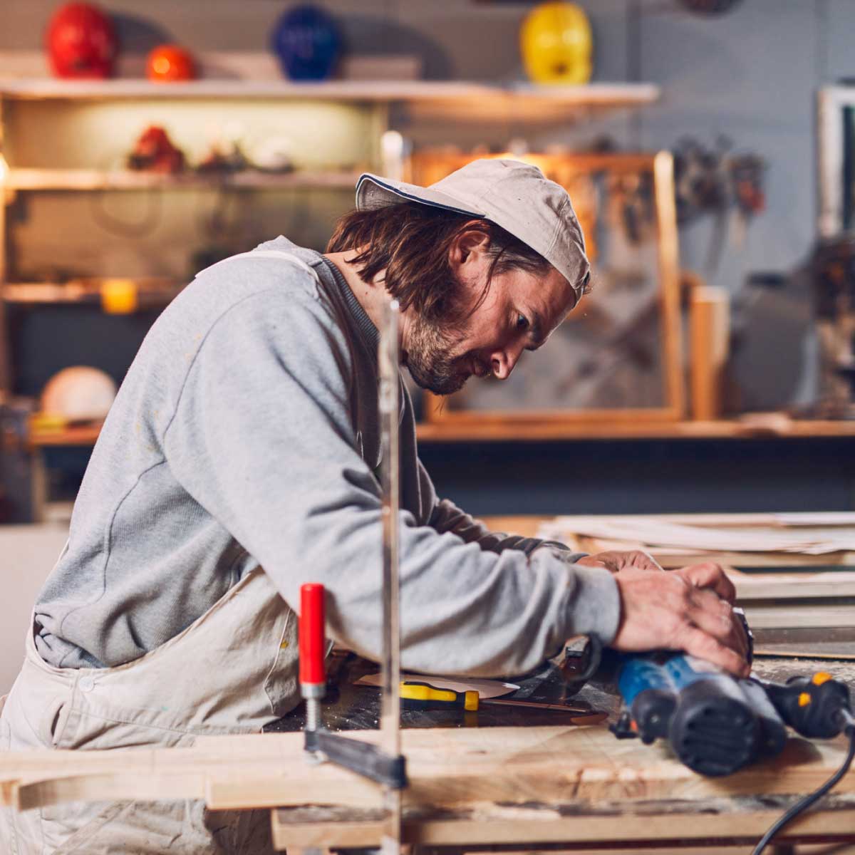 Male carpenter working on old wood in a retro vintage workshop