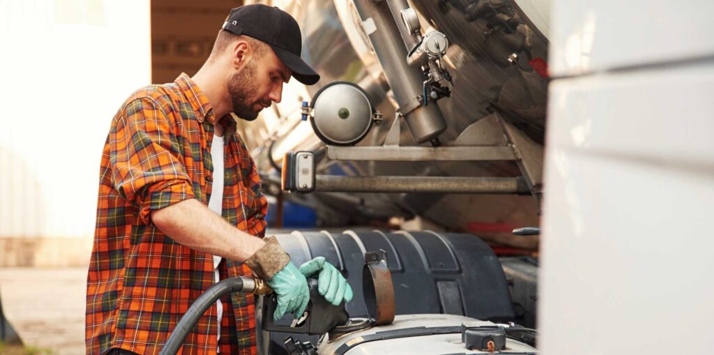 Holding refueling device. Young truck driver in casual clothes stock photo