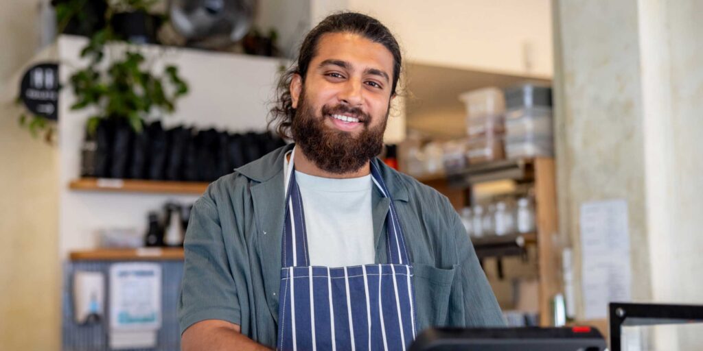 Australian cafe manager smiling at camera