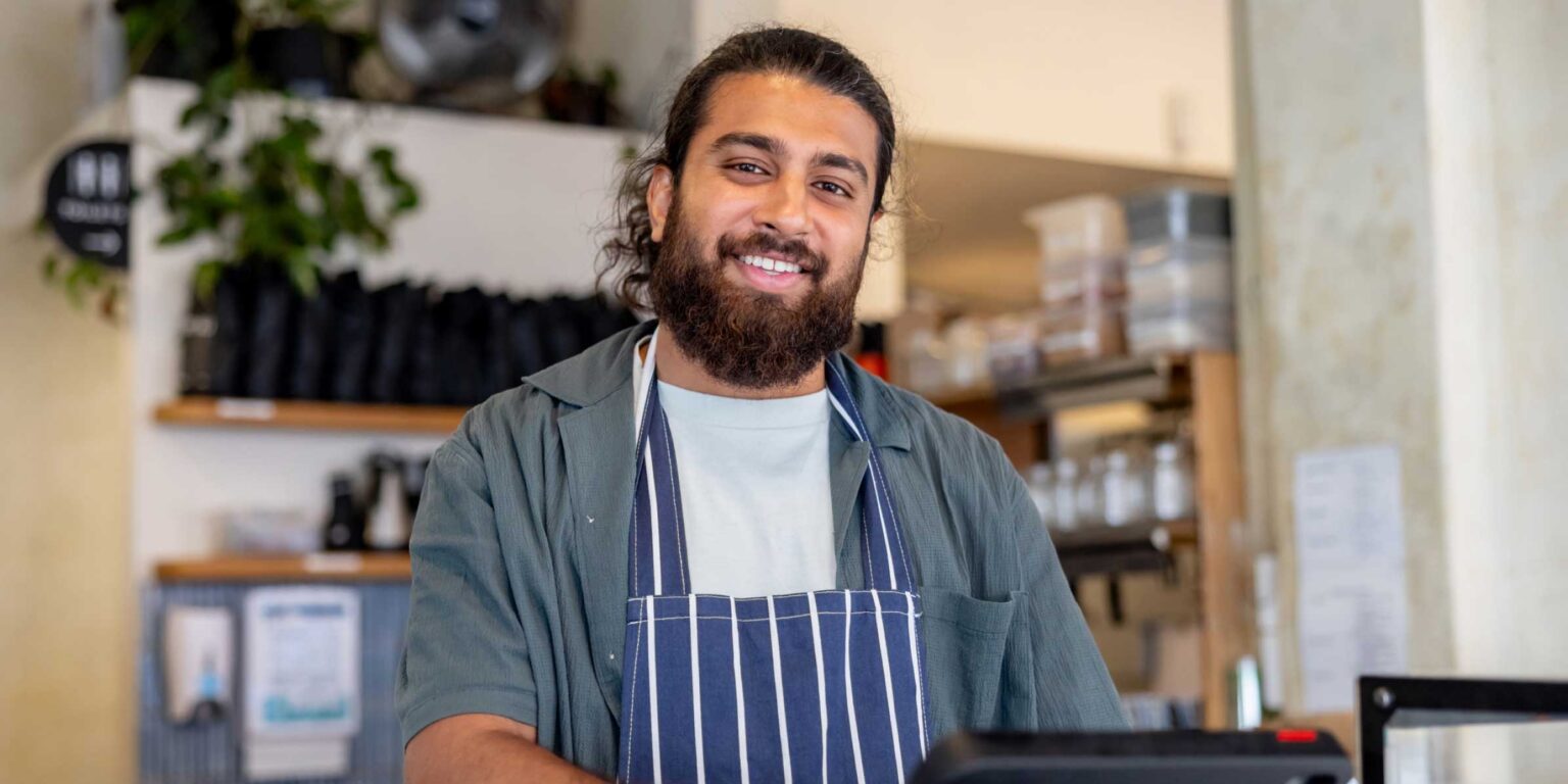 Australian cafe manager smiling at camera