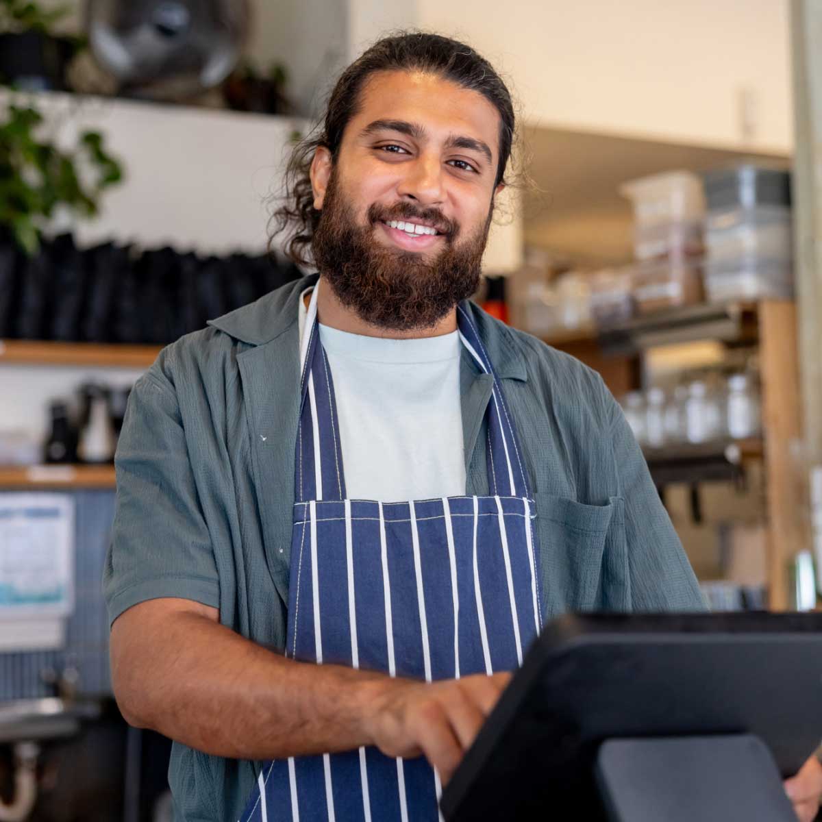 Australian cafe manager smiling at camera