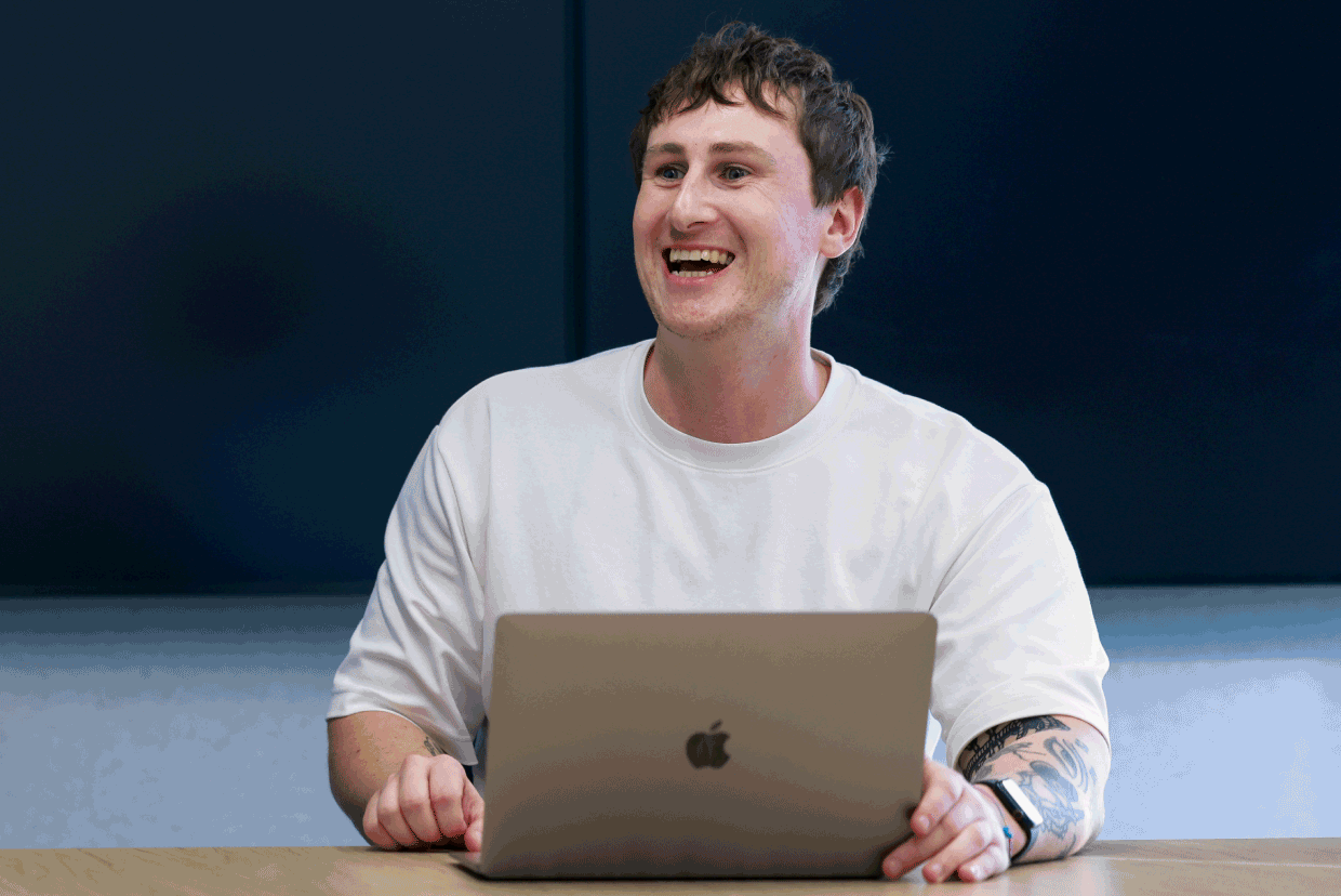 Person sitting at a desk with a laptop during a workplace meeting in a modern office.