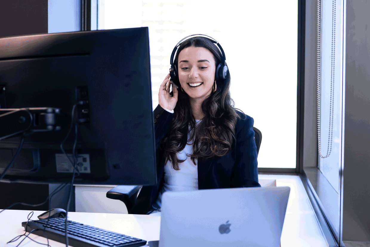 Employee working at a desk while wearing a headset during a video or phone call.