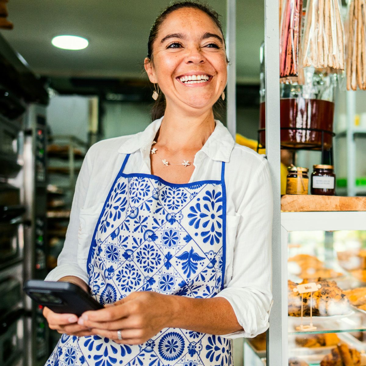 Proud business owner holding a phone
